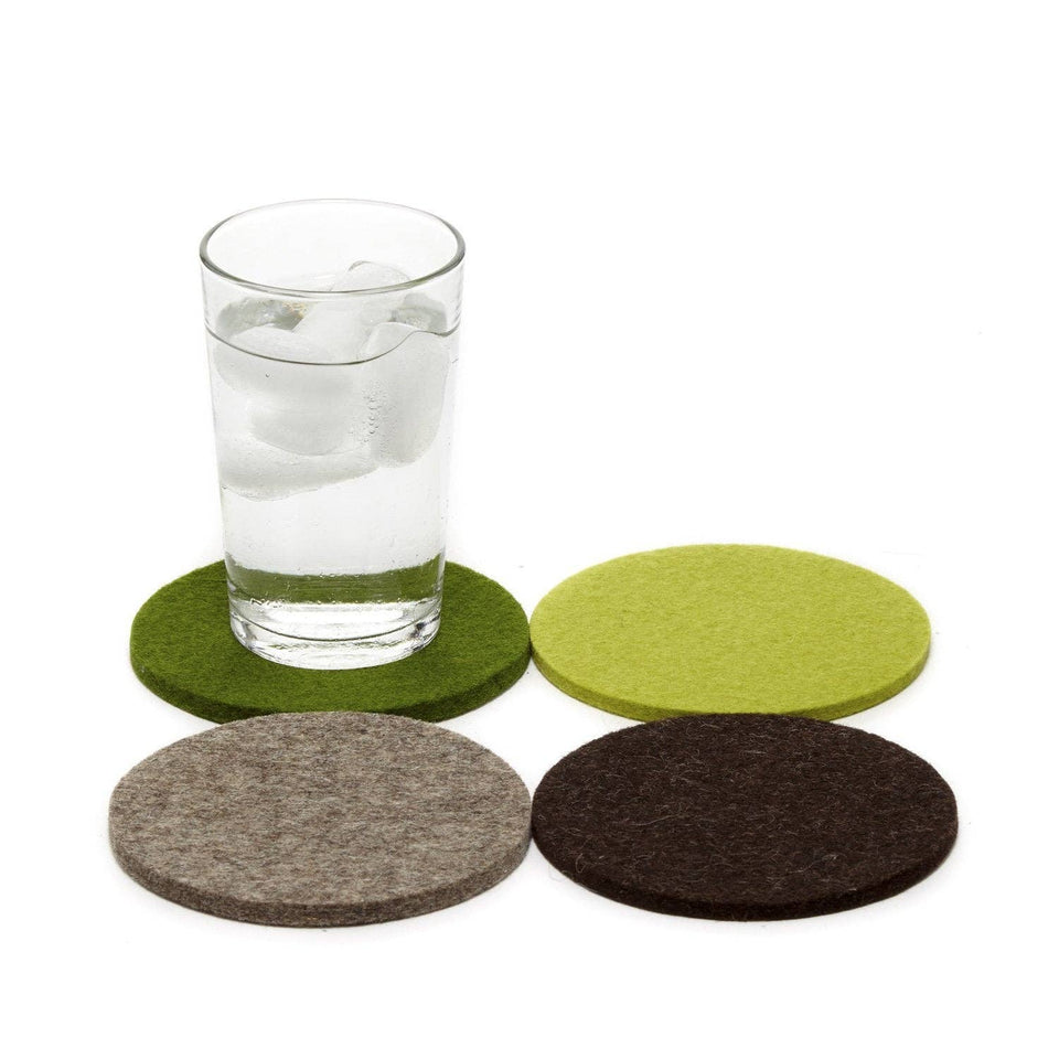 Set of round felt coasters in green, brown, and gray with a glass of water on a white background.