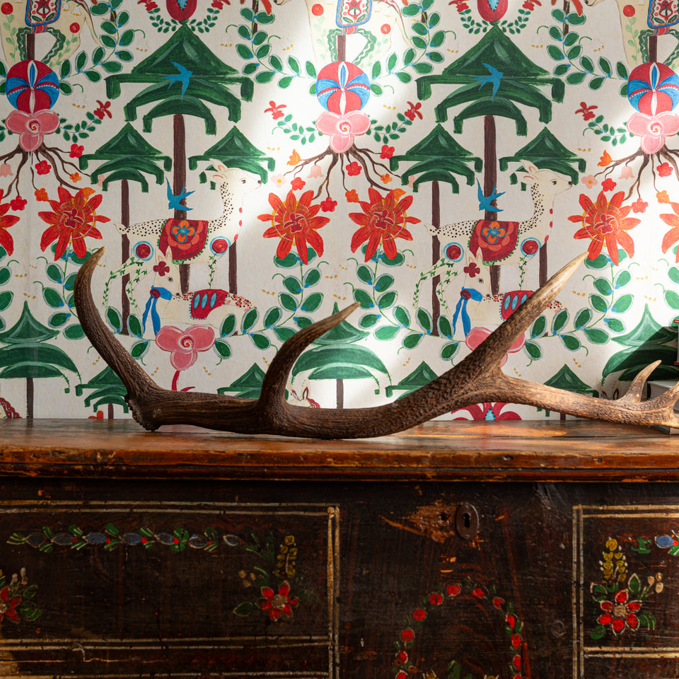 A Woodland Tale Cream wallpaper by MINDTHEGAP, close-up in a styled interior.