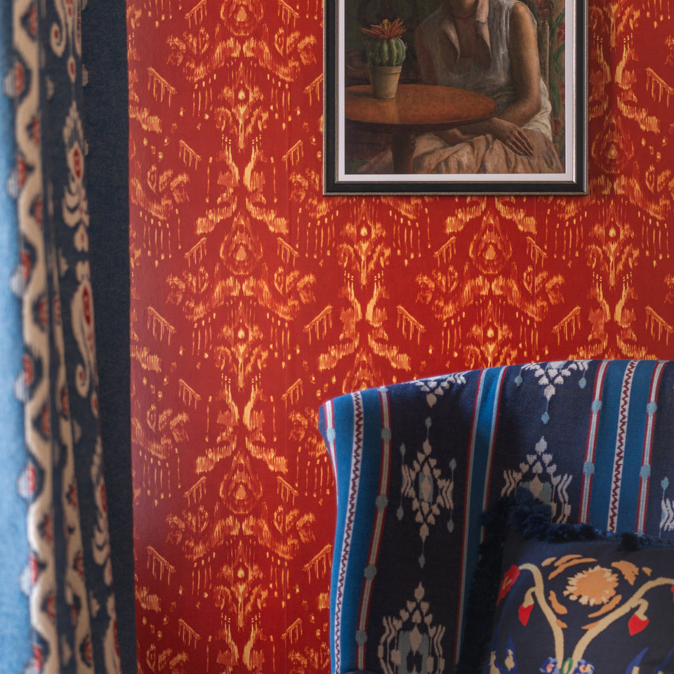 Ancestral Ikat Copper wallpaper by MINDTHEGAP, close-up in a styled interior.