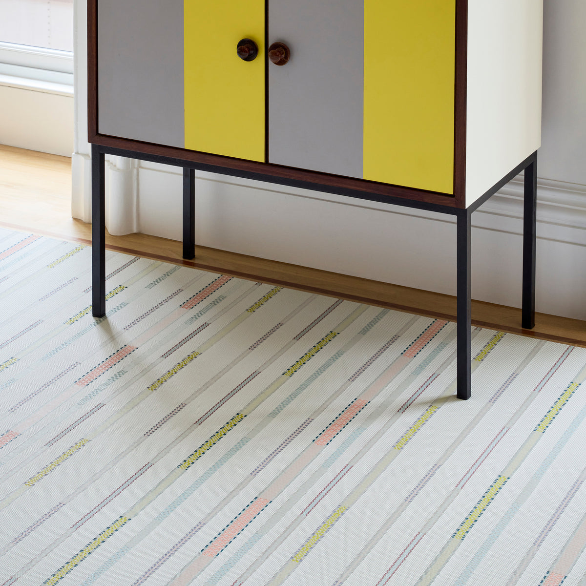 Chilewich Appliqué woven floor mat in Almond in an interior setting