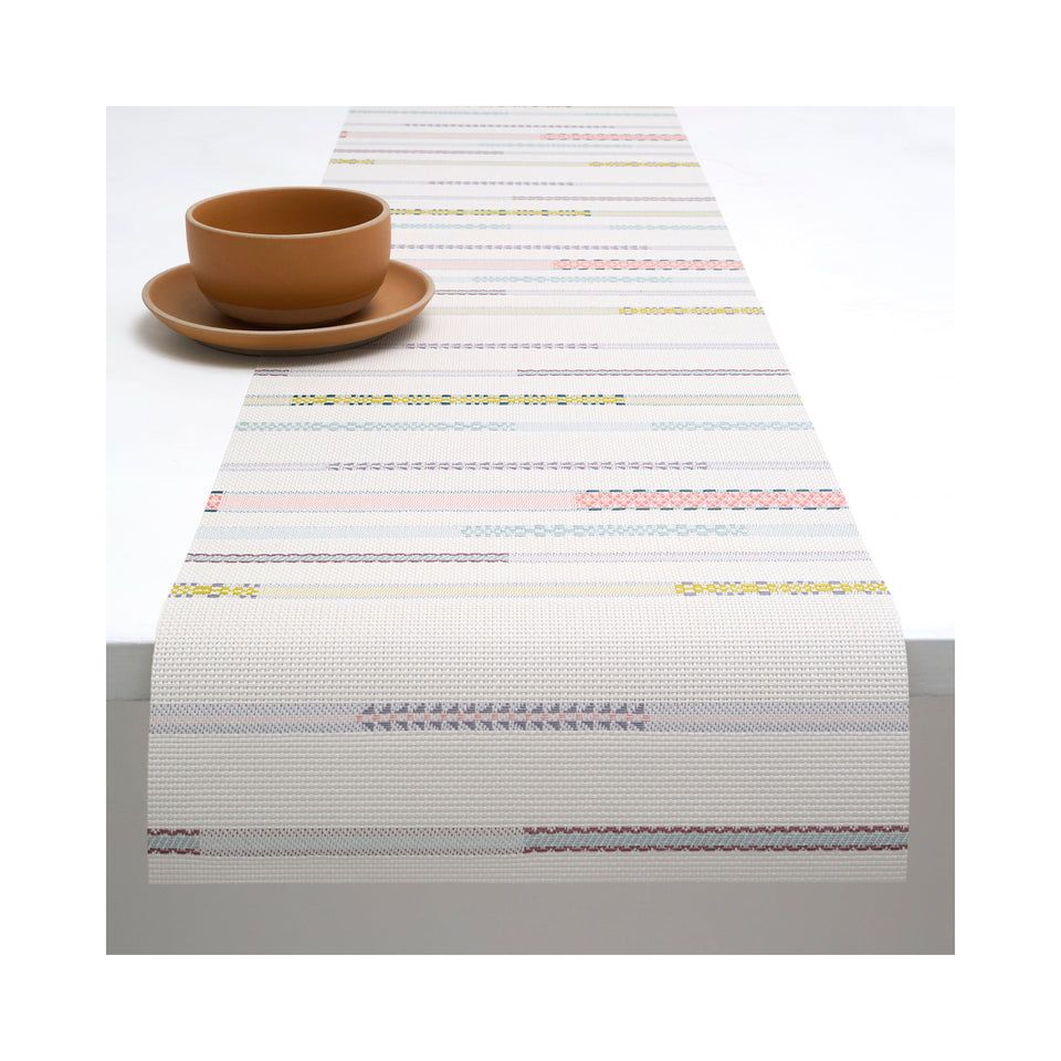 Chilewich Appliqué table runner in Almond, draped across a table