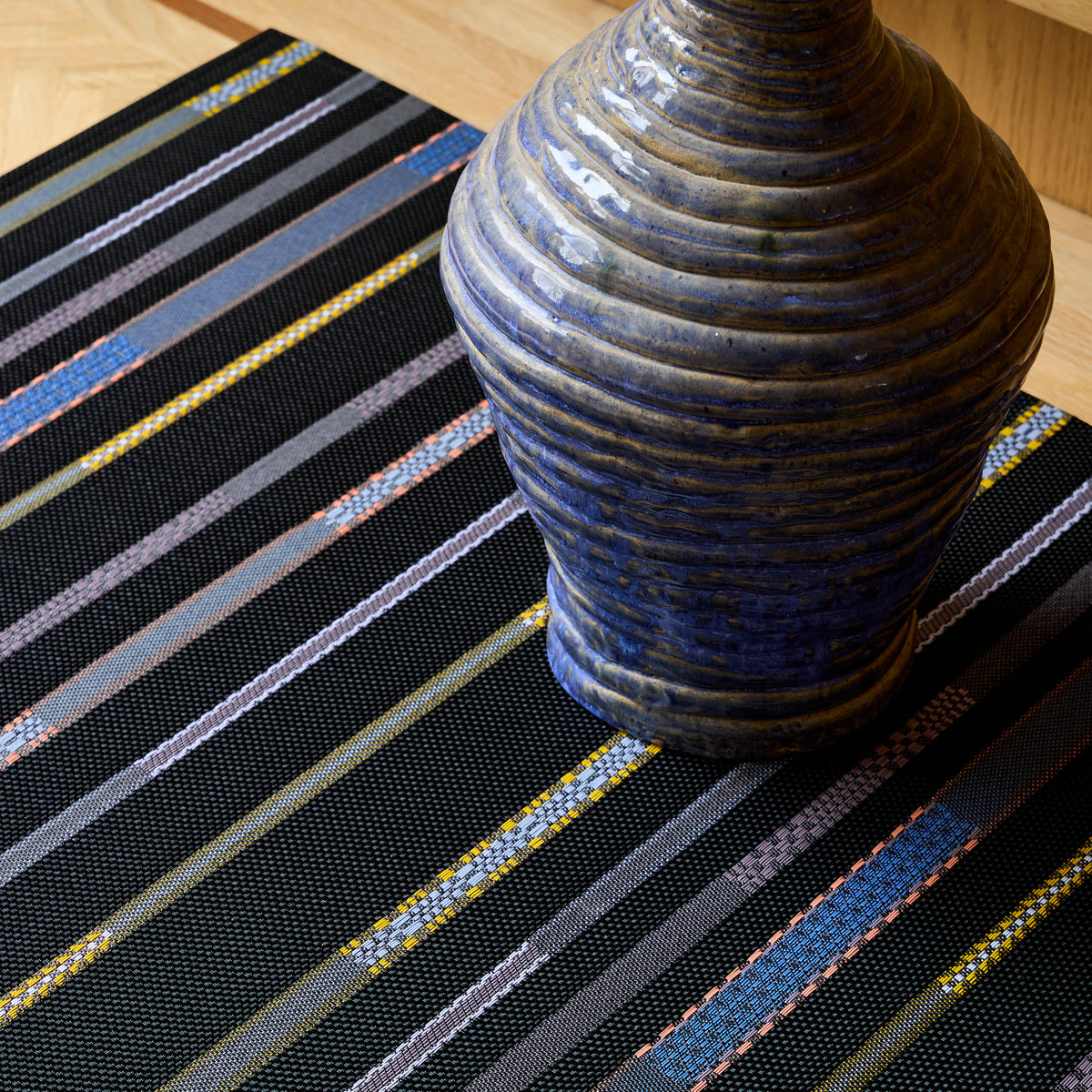 Chilewich Appliqué woven floor mat in Nero in an interior setting