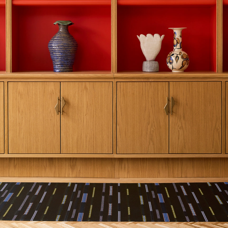 Chilewich Appliqué woven floor mat in Nero in an interior setting