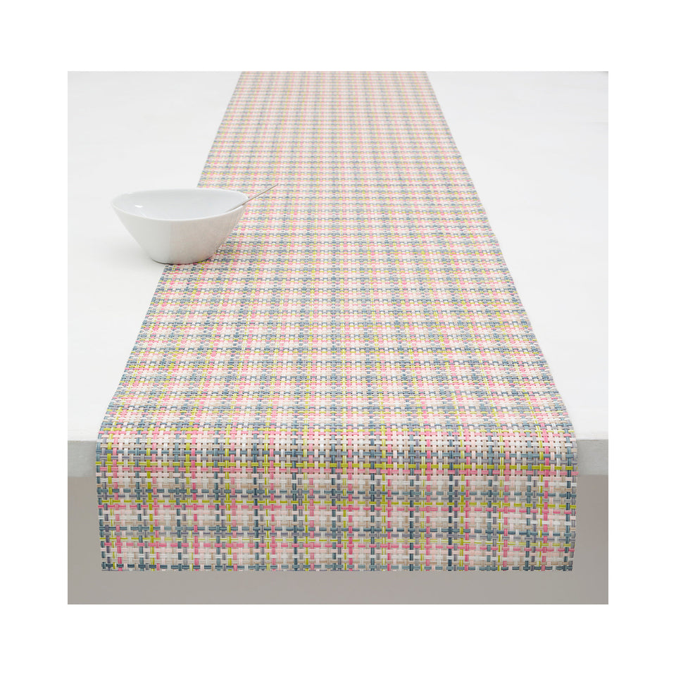 Chilewich Basketweave table runner in Begonia, draped across a table