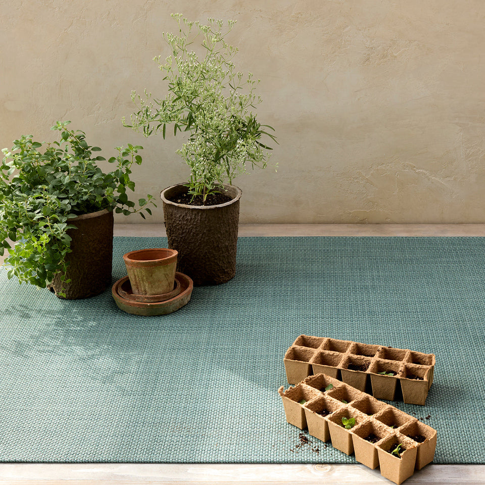 Basketweave / Celadon woven floor mat by Chilewich, interior setting