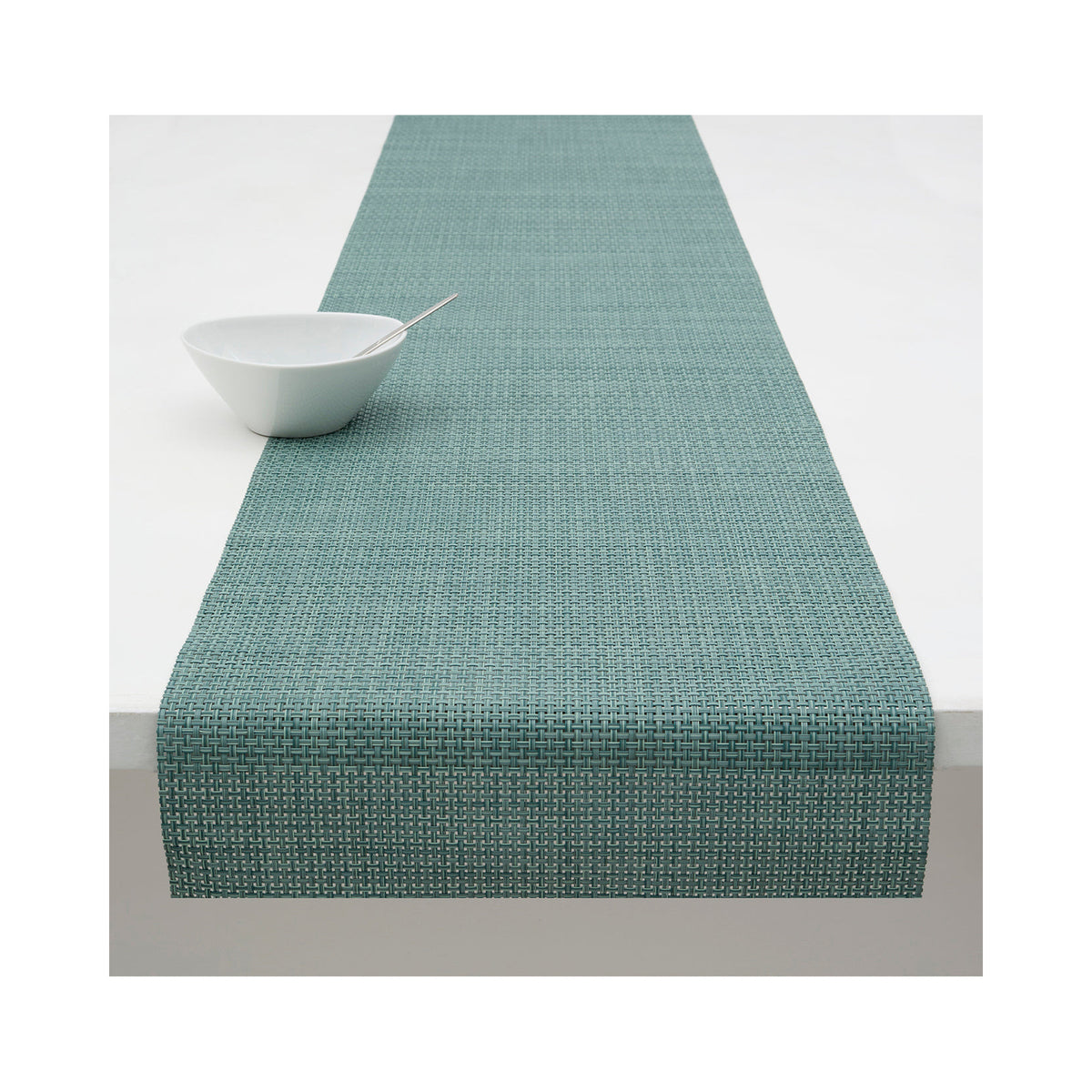 Chilewich Basketweave table runner in Celadon, draped across a table