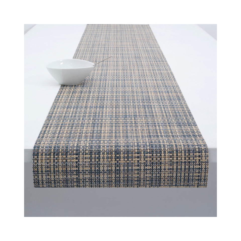Chilewich Basketweave table runner in Coast, draped across a table