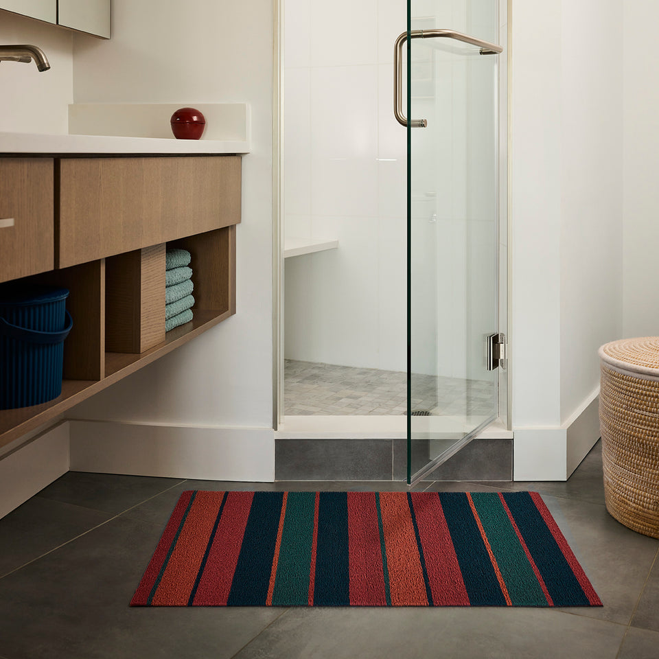Raspberry Bolt Stripe Shag Mat by Chilewich — in an indoor setting
