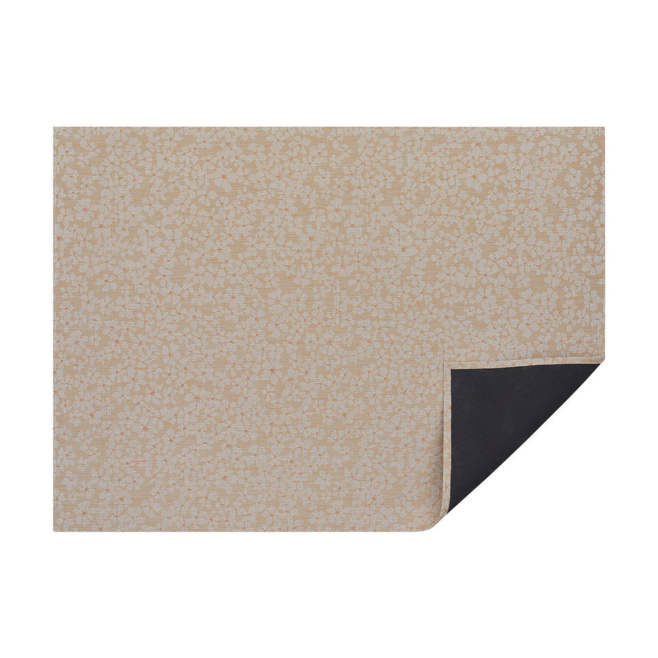 Almond Flora woven floor mat by Chilewich, horizontal folded-corner view