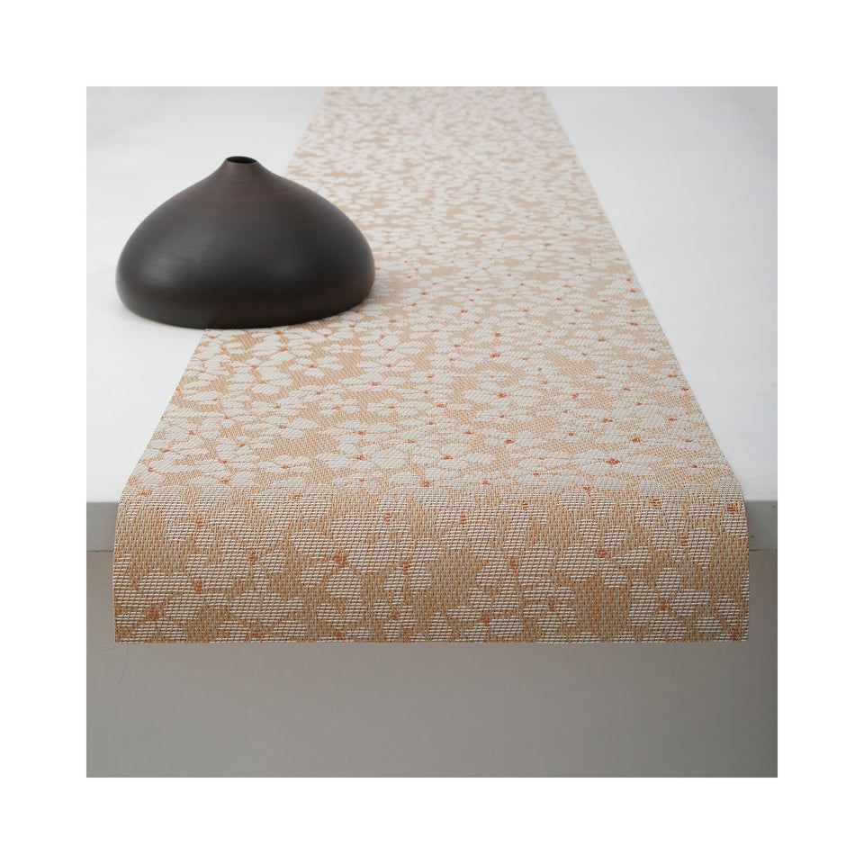 Chilewich Flora table runner in Almond, draped across a table