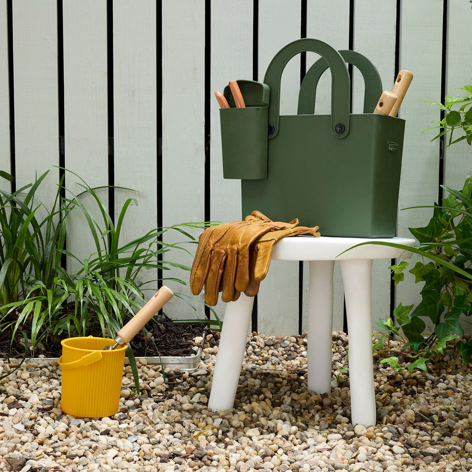 Garden Green Hachiman tote holding garden tools beside plants