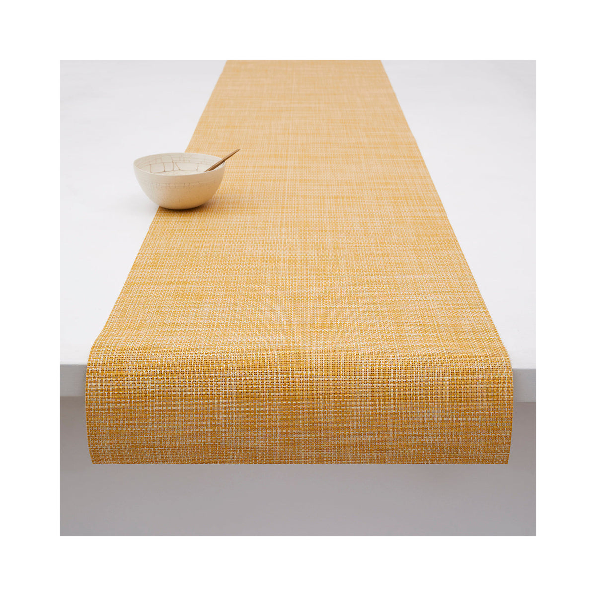 Chilewich Mini Basketweave table runner in Ochre, draped across a table