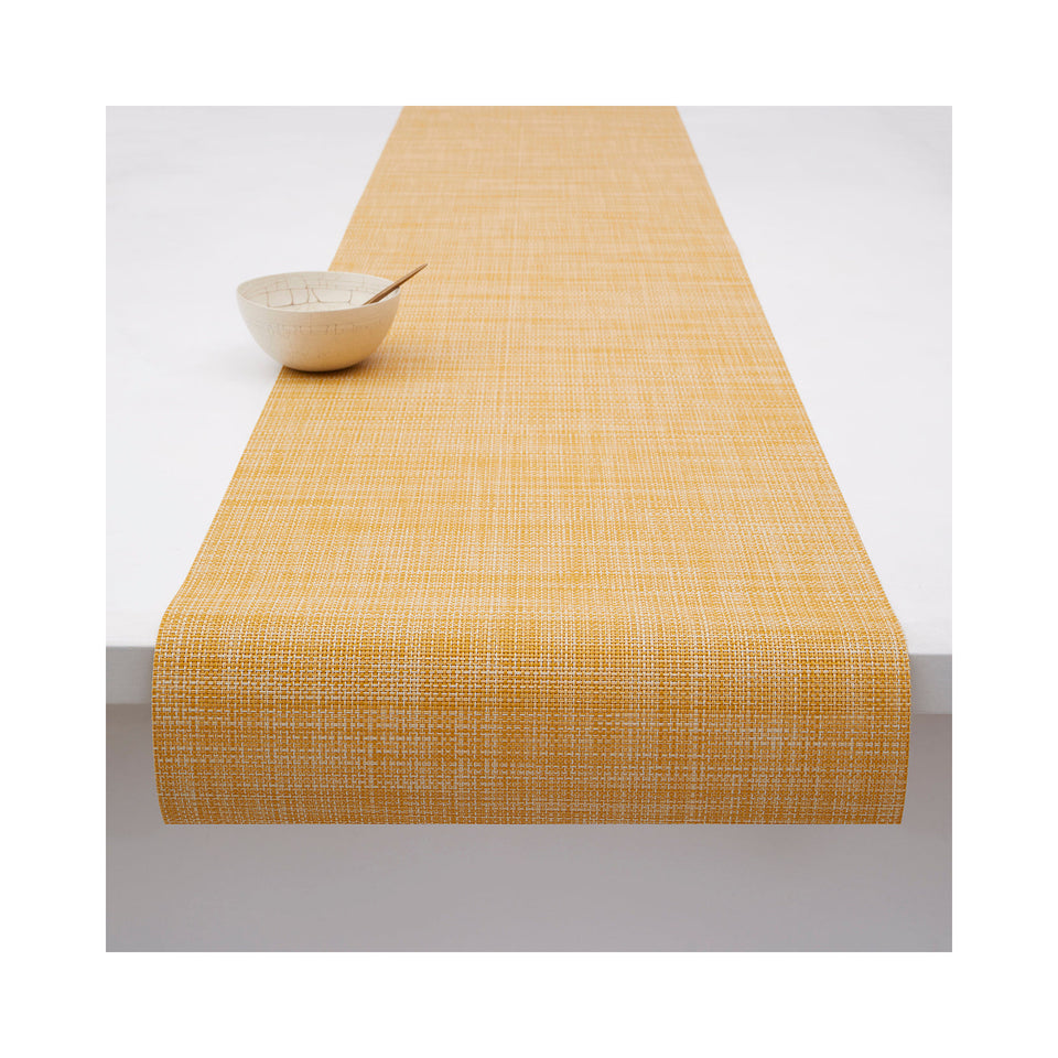 Chilewich Mini Basketweave table runner in Ochre, draped across a table