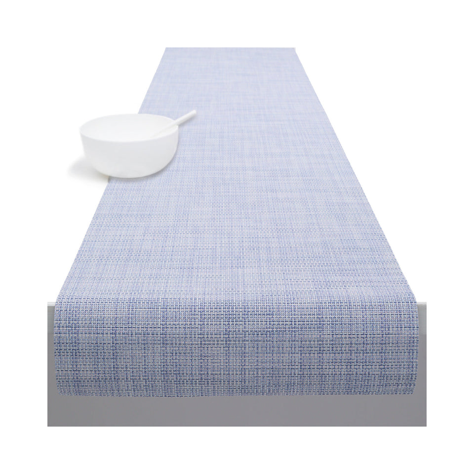 Chilewich Mini Basketweave table runner in Periwinkle, draped across a table