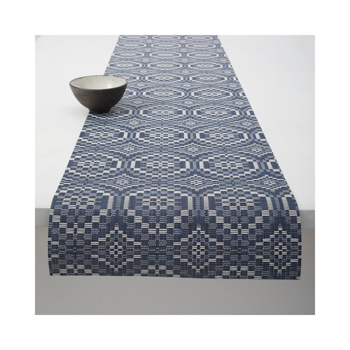 Chilewich Overshot table runner in Denim, draped across a table