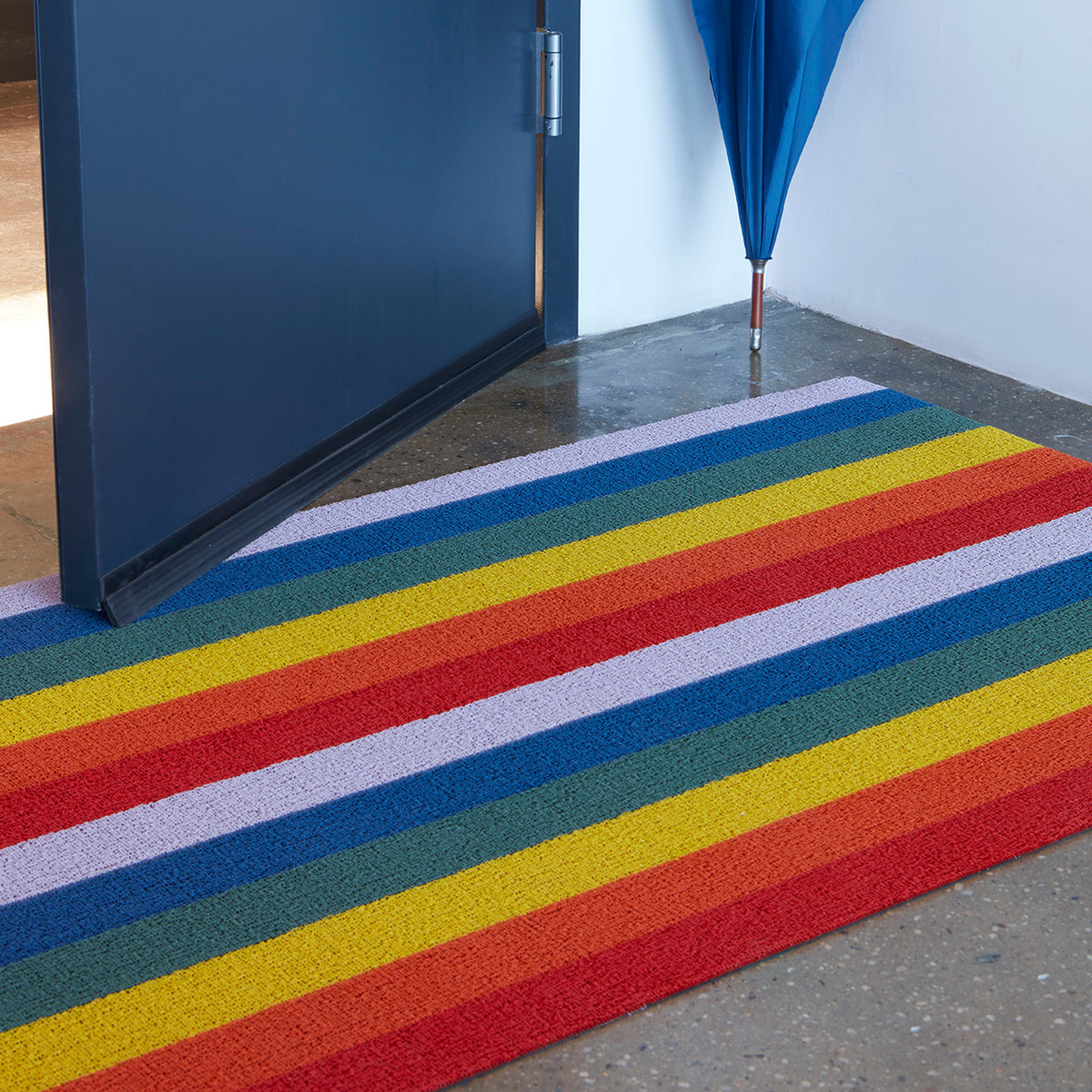 Rainbow Pride Stripe Shag Mat by Chilewich — in an indoor setting
