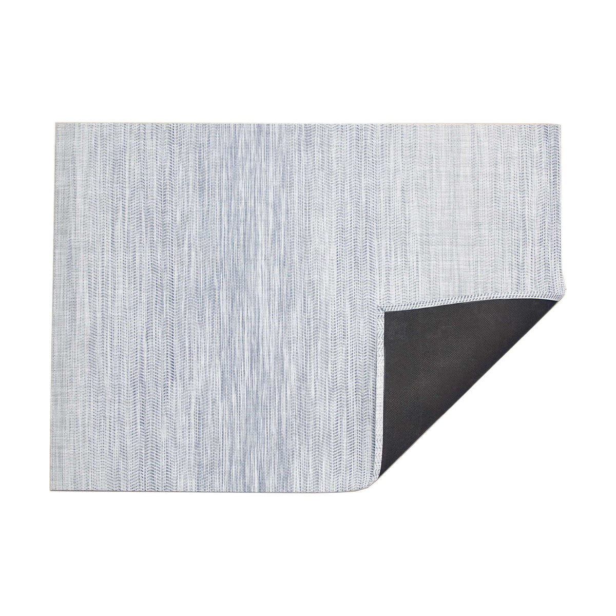 Wave / Blue woven floor mat by Chilewich, folded-corner studio view