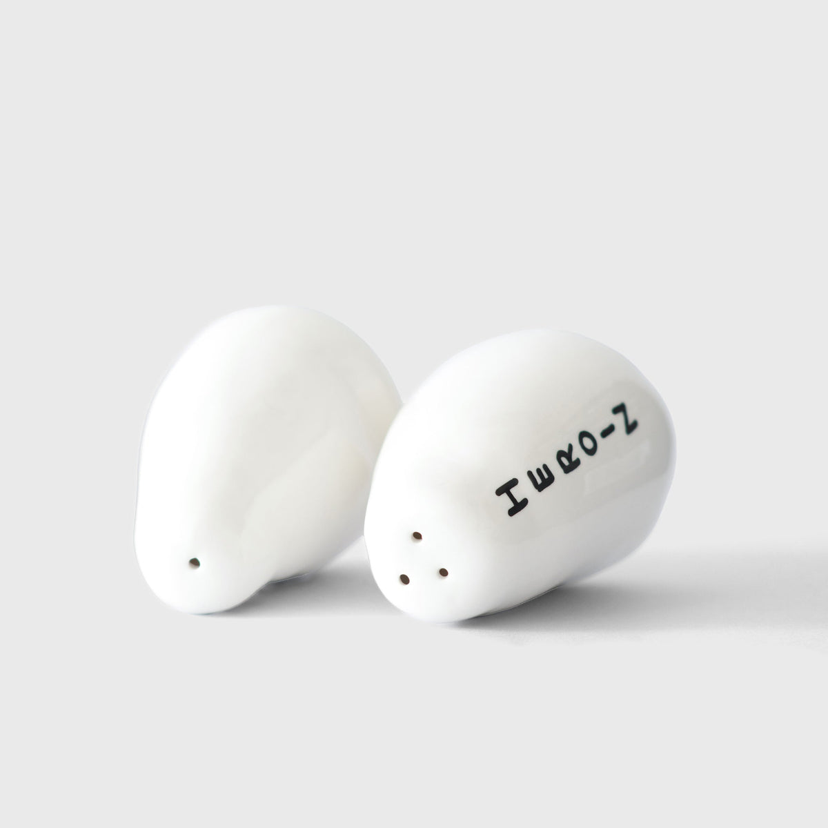 Hand placing David Shrigley Heroin and Cocaine shakers on a table
