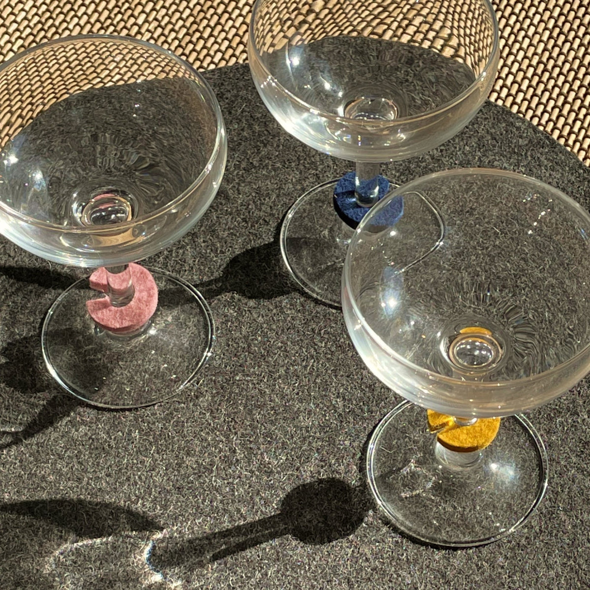 Graf Lantz Wine glasses with colorful felt markers on dark felt and a woven table surface