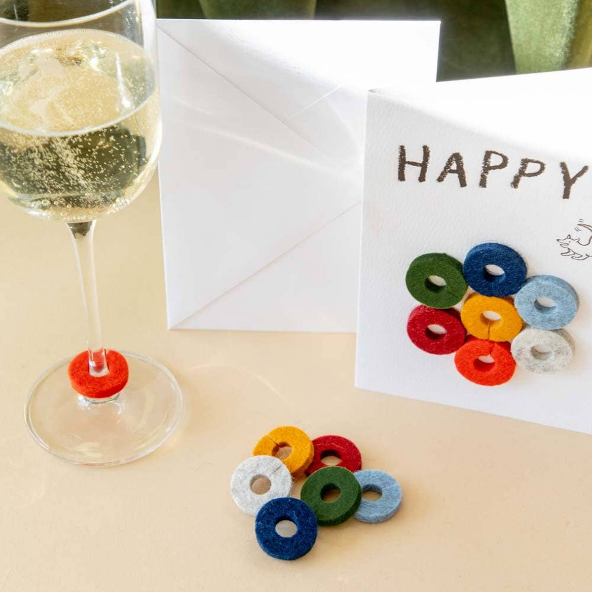 Graf Lantz Happy Wine-Ote’s card and colorful felt markers beside a glass of sparkling wine
