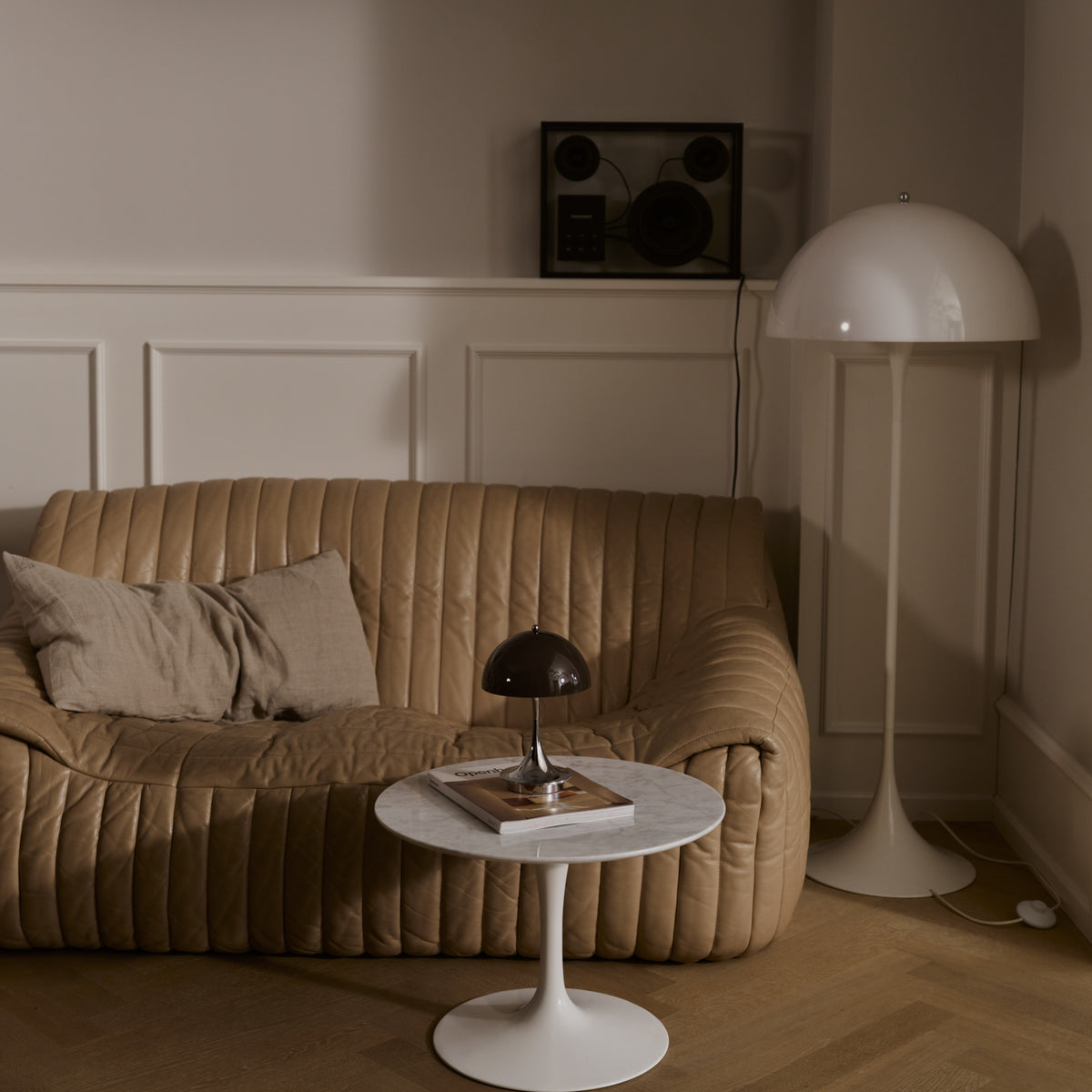 Original Opal Brown Panthella 160 Portable lamp on a side table beside a sofa.