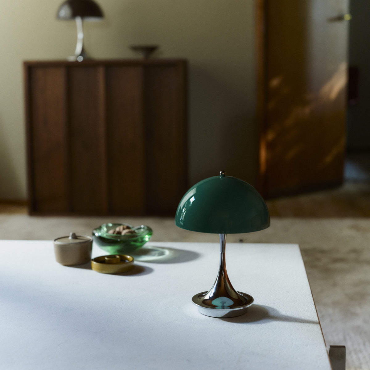 Original Opal Green Panthella 160 Portable lamp with chrome base on a coffee table.