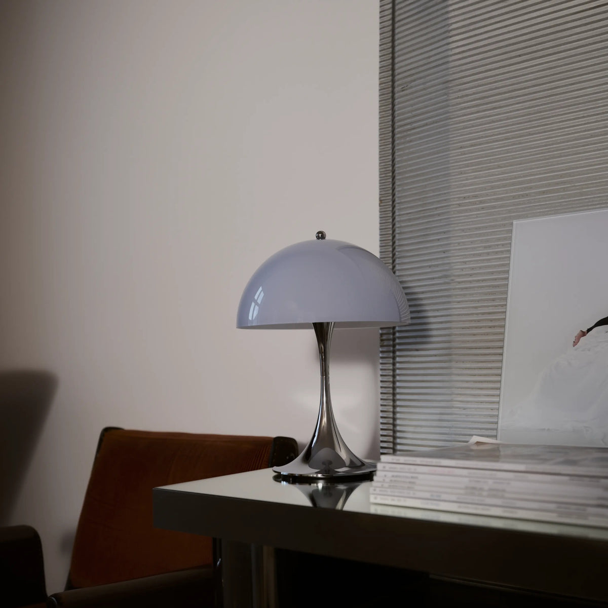 Chrome Opal Blue Grey Panthella 250 Portable Lamp on a windowsill.