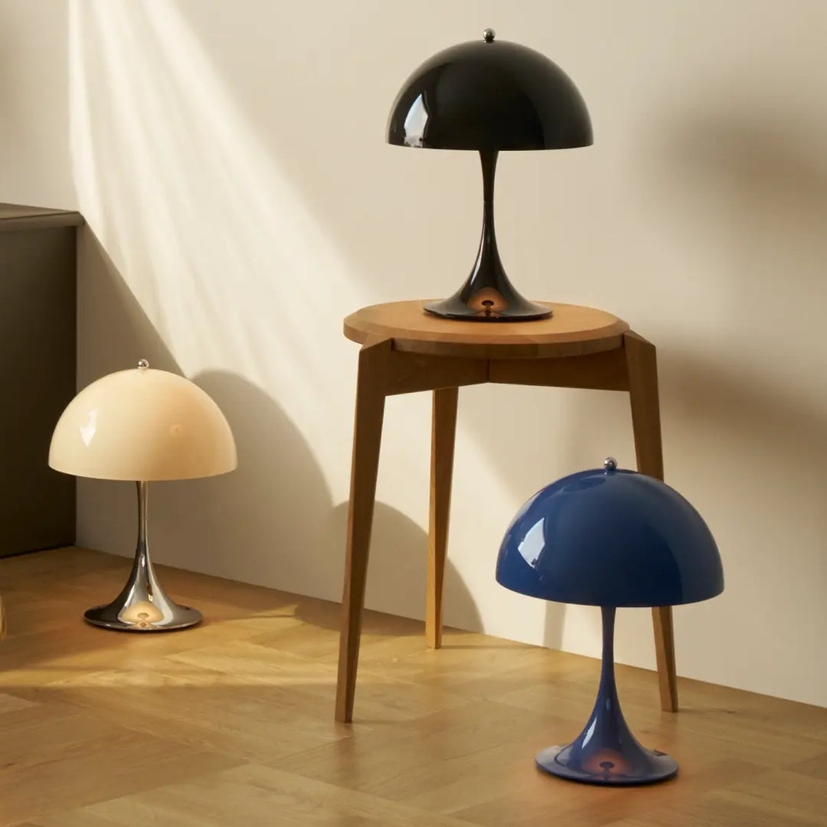 Panthella 250 Portable Lamps in Chrome Opal Beige, Opaque Black and Opaque Indigo Blue on display.