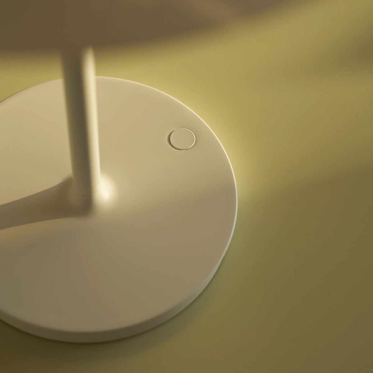Close-up of the White PH 80 Portable Lamp base and dimming button.
