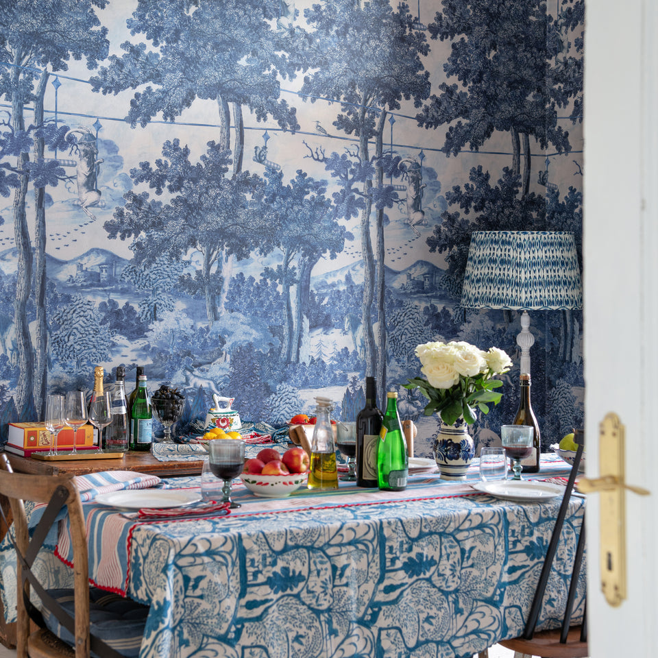 Toile Du Carpathians Indigo wallpaper by MINDTHEGAP, shown in a furnished interior.