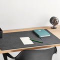 Vitra Repad in black on a wooden desk; desk accessories sold separately