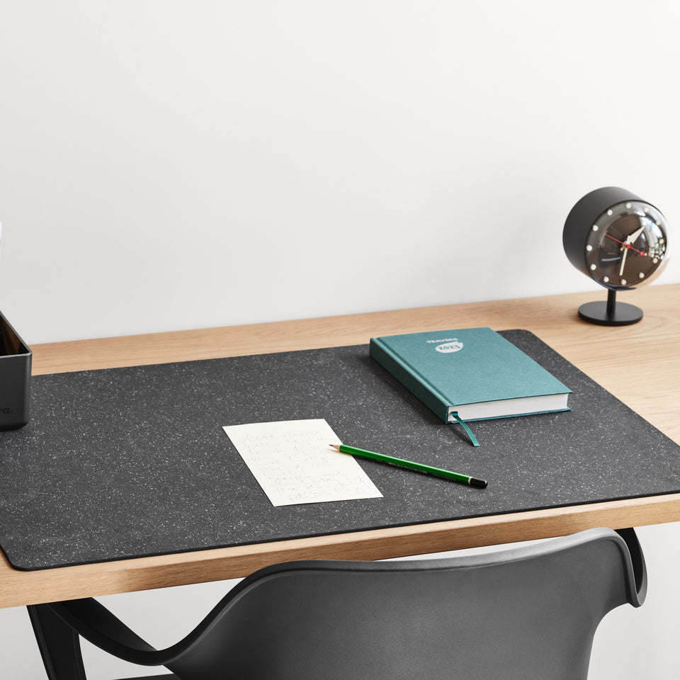 Vitra Repad in black on a wooden desk; desk accessories sold separately