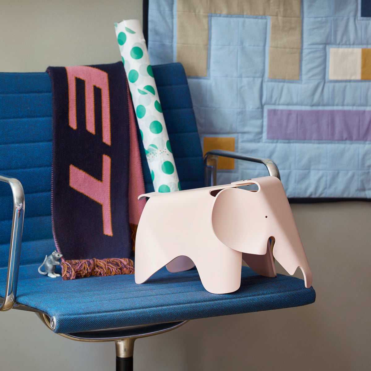 Pale rose Eames Elephant Small displayed on a chair with books