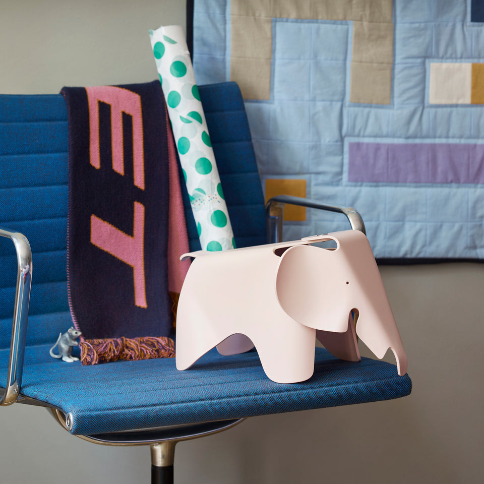 Pale rose Eames Elephant Small displayed on a chair with books